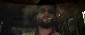 Movie still from “Zeroville” (2019), directed by James Franco – A man with a beard and sunglasses smoking a cigarette; Close Up shot, Low angle