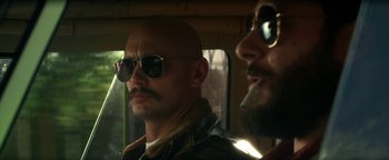 Movie still from “Zeroville” (2019), directed by James Franco – A man with a beard and sunglasses in a car; Close Up shot, Low angle