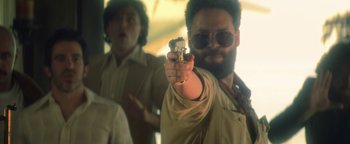 Movie still from “Zeroville” (2019), directed by James Franco – A man holding up a gun in front of another man; Medium shot, Over the shoulder angle