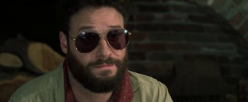 Movie still from “Zeroville” (2019), directed by James Franco – A man with a beard wearing sunglasses and a tie; Close Up shot, Over the shoulder angle