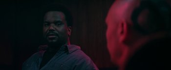 Movie still from “Zeroville” (2019), directed by James Franco – A man standing next to another man in front of a wooden wall; Close Up shot, Over the shoulder angle