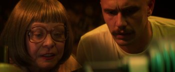Movie still from “Zeroville” (2019), directed by James Franco – A man and a woman looking at something on a table; Close Up shot, Over the shoulder angle