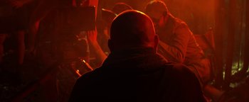 Movie still from “Zeroville” (2019), directed by James Franco – A man with a bald head is looking at a crowd; Extreme Close Up shot, Over the shoulder angle