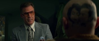 Movie still from “Zeroville” (2019), directed by James Franco – An older man in a suit and tie holding a cell phone; Close Up shot, Over the shoulder angle