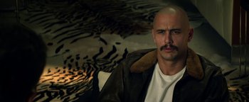 Movie still from “Zeroville” (2019), directed by James Franco – A man with a bald head wearing a leather jacket; Close Up shot, High angle