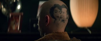 Movie still from “Zeroville” (2019), directed by James Franco – A bald man with an image of a woman on his head; Extreme Close Up shot, Over the shoulder angle