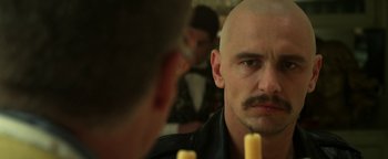 Movie still from “Zeroville” (2019), directed by James Franco – A man with a bald head looking at himself in the mirror; Close Up shot, Over the shoulder angle