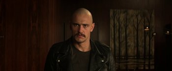 Movie still from “Zeroville” (2019), directed by James Franco – A man with a shaved head and a mustache; Close Up shot, Low angle