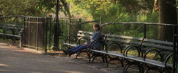 Movie still from “Zeroville” (2019), directed by James Franco – A woman sitting on top of a wooden park bench; Wide shot, High angle