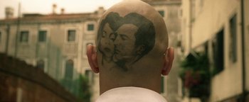 Movie still from “Zeroville” (2019), directed by James Franco – A man's head with a picture of a man and a woman on it; Extreme Close Up shot, Over the shoulder angle
