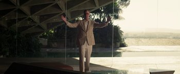 Movie still from “Zeroville” (2019), directed by James Franco – A man in a tan suit standing in front of a pool; Wide shot, Low angle