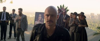 Movie still from “Zeroville” (2019), directed by James Franco – A man with a shaved head and a black jacket; Close Up shot, Over the shoulder angle