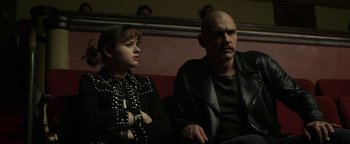 Movie still from “Zeroville” (2019), directed by James Franco – A man and a woman sitting next to each other on a bench; Medium shot, Low angle