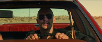 Movie still from “Zeroville” (2019), directed by James Franco – A man with a mustache driving a red car; Close Up shot, Low angle