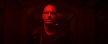 Movie still from “Zeroville” (2019), directed by James Franco – A man with a bald head is in a dark room; Close Up shot, Low angle