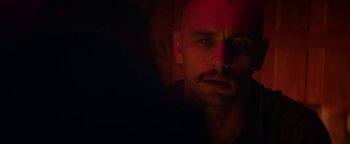 Movie still from “Zeroville” (2019), directed by James Franco – A man with a beard and a mustache in the dark; Close Up shot, Over the shoulder angle
