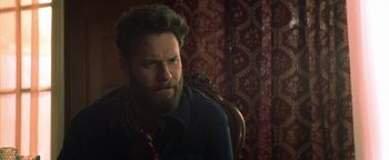 Movie still from “Zeroville” (2019), directed by James Franco – A bearded man sitting in a chair looking at the camera; Close Up shot, Over the shoulder angle