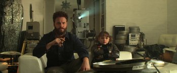 Movie still from “Zeroville” (2019), directed by James Franco – A man sitting next to a little girl in a room; Medium shot, Over the shoulder angle