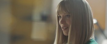 Movie still from “Zoe” (2018), directed by Drake Doremus – A young girl with blonde hair and blue eyes; Close Up shot, Over the shoulder angle