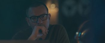 Movie still from “Zoe” (2018), directed by Drake Doremus – A person wearing glasses; Close Up shot, Over the shoulder angle
