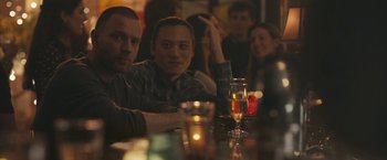 Movie still from “Zoe” (2018), directed by Drake Doremus – A group of people sitting at a table with wine glasses; Medium shot, Over the shoulder angle