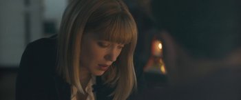 Movie still from “Zoe” (2018), directed by Drake Doremus – A person with a candle in the background; Close Up shot, Over the shoulder angle