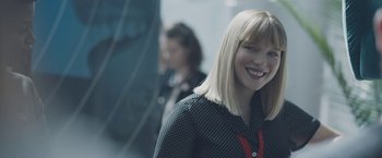 Movie still from “Zoe” (2018), directed by Drake Doremus – A woman with blonde straight hair smiles for the camera; Close Up shot, Over the shoulder angle