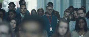 Movie still from “Zoe” (2018), directed by Drake Doremus – A group of people standing around a room; Medium shot, Over the shoulder angle