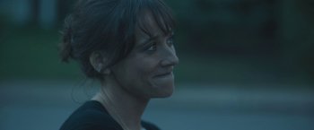 Movie still from “Zoe” (2018), directed by Drake Doremus – A person smiling; Close Up shot, Over the shoulder angle