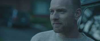 Movie still from “Zoe” (2018), directed by Drake Doremus – A man with a beard is wearing a white sweater; Close Up shot, Over the shoulder angle