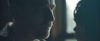 Movie still from “Zoe” (2018), directed by Drake Doremus – A man's face in a dark room; Extreme Close Up shot, Over the shoulder angle