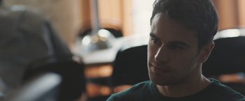 Movie still from “Zoe” (2018), directed by Drake Doremus – A person sitting in a room; Close Up shot, Over the shoulder angle