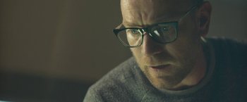 Movie still from “Zoe” (2018), directed by Drake Doremus – A person wearing glasses; Close Up shot, Over the shoulder angle