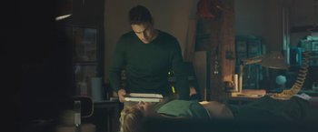 Movie still from “Zoe” (2018), directed by Drake Doremus – A man standing next to a woman laying on a bed; Medium shot, Over the shoulder angle