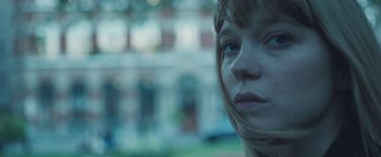 Movie still from “Zoe” (2018), directed by Drake Doremus – A woman's face in front of a building; Close Up shot, Over the shoulder angle