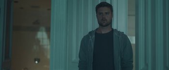 Movie still from “Zoe” (2018), directed by Drake Doremus – A man standing in front of a window in a room; Medium shot, Low angle