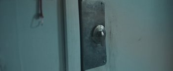 Movie still from “Zoe” (2018), directed by Drake Doremus – A door knob on a metal door; Extreme Close Up shot, High angle