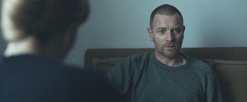 Movie still from “Zoe” (2018), directed by Drake Doremus – A man sitting in front of another man in front of a couch; Close Up shot, Over the shoulder angle