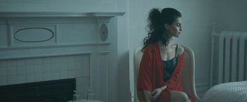 Movie still from “Zoe” (2018), directed by Drake Doremus – A woman in a red dress standing in front of a mirror; Medium shot, Low angle