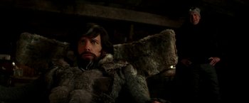 Movie still from “Zoolander 2” (2016), directed by Ben Stiller – A man with long hair and a beard sitting in a chair; Medium shot, Low angle
