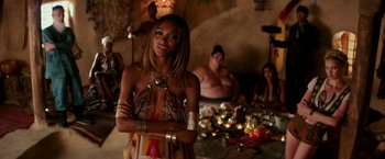 Movie still from “Zoolander 2” (2016), directed by Ben Stiller – A woman standing in front of a group of people; Medium shot, Over the shoulder angle