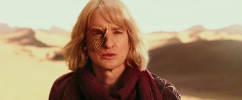 Movie still from “Zoolander 2” (2016), directed by Ben Stiller – A woman with a gold eye patch on her face; Close Up shot, Over the shoulder angle