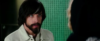 Movie still from “Zoolander 2” (2016), directed by Ben Stiller – A man with long hair and a goatee stares at a woman; Close Up shot, Over the shoulder angle