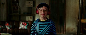 Movie still from “Zoolander 2” (2016), directed by Ben Stiller – A young man wearing red headphones and a striped shirt; Close Up shot, Over the shoulder angle