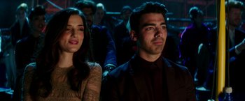 Movie still from “Zoolander 2” (2016), directed by Ben Stiller – A man and a woman are sitting in front of a group of people; Close Up shot, High angle