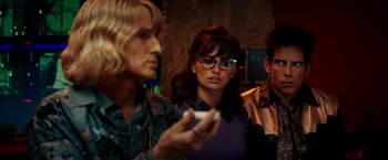 Movie still from “Zoolander 2” (2016), directed by Ben Stiller – A group of people standing next to each other holding a game controller; Medium shot, Over the shoulder angle