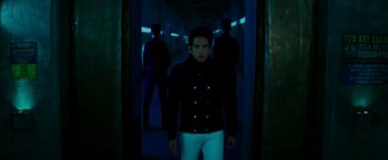 Movie still from “Zoolander 2” (2016), directed by Ben Stiller – A man in a black jacket standing in a dark room; Medium shot, Low angle