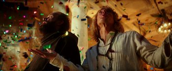 Movie still from “Zoolander 2” (2016), directed by Ben Stiller – Two men in medieval garb are standing in front of confetti; Medium shot, Low angle