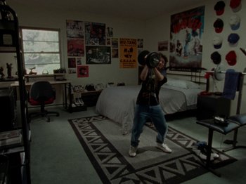 Movie still from “Mid90s” (2018), directed by Jonah Hill – A man holding up a camera in a room; Wide shot, High angle