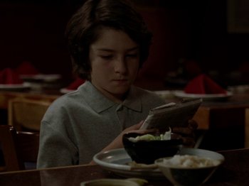 Movie still from “Mid90s” (2018), directed by Jonah Hill – A young boy sitting in front of a bowl of food; Close Up shot, High angle